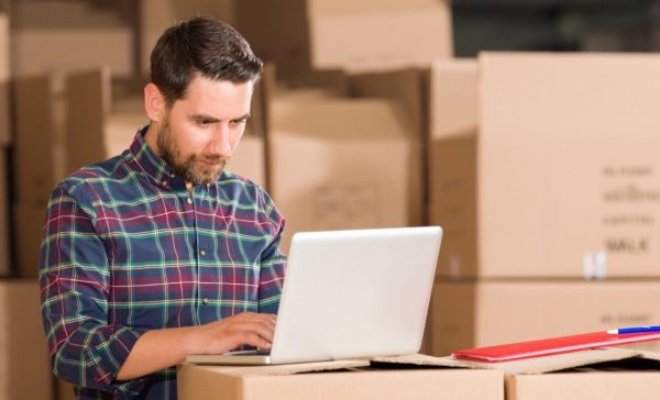 a businessman using his laptop that's on a stack of boxes
