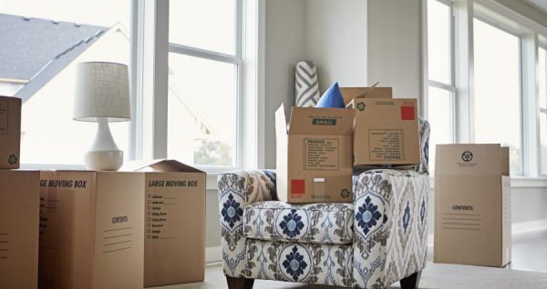 stacks of cardboard boxes and a small couch in an empty room