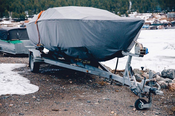 A boat wrapped in a cover outside in the snow