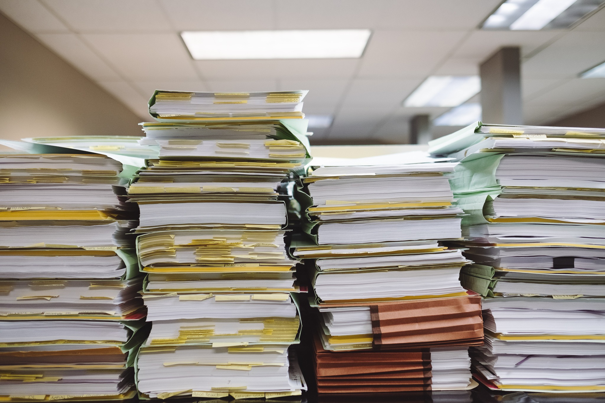 A pile of files staked up on a desk